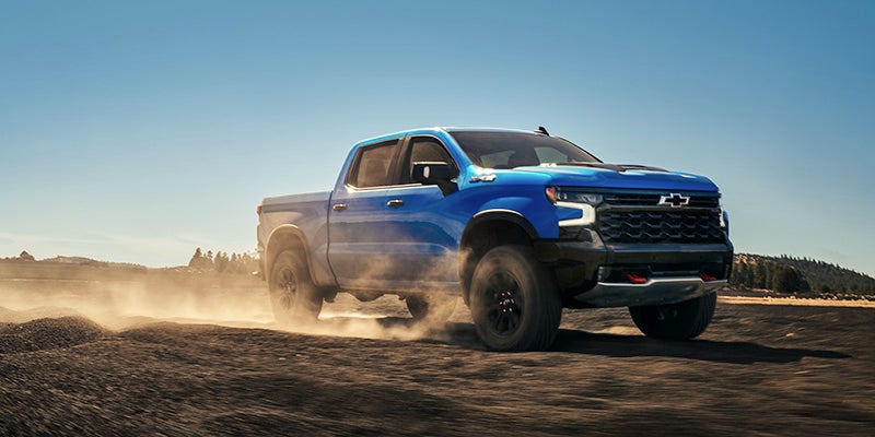 A blue truck driving off-road.