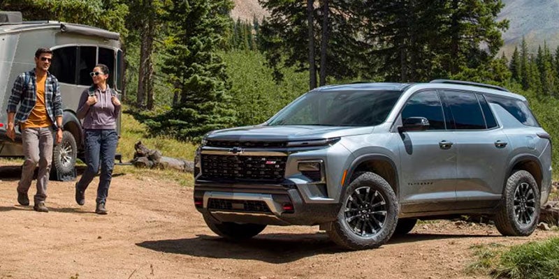 A gray suv sitting parked off-road.
