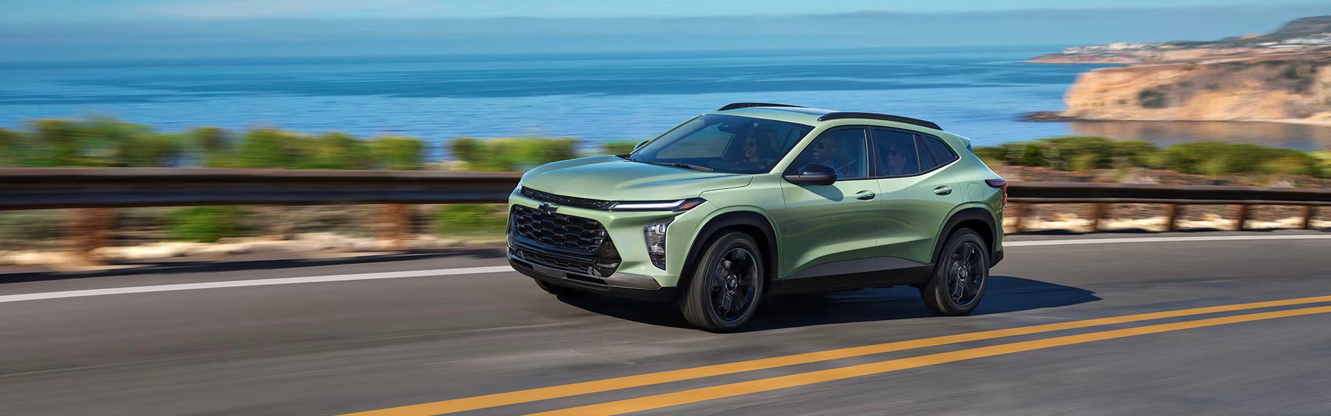 A green suv driving on the road.