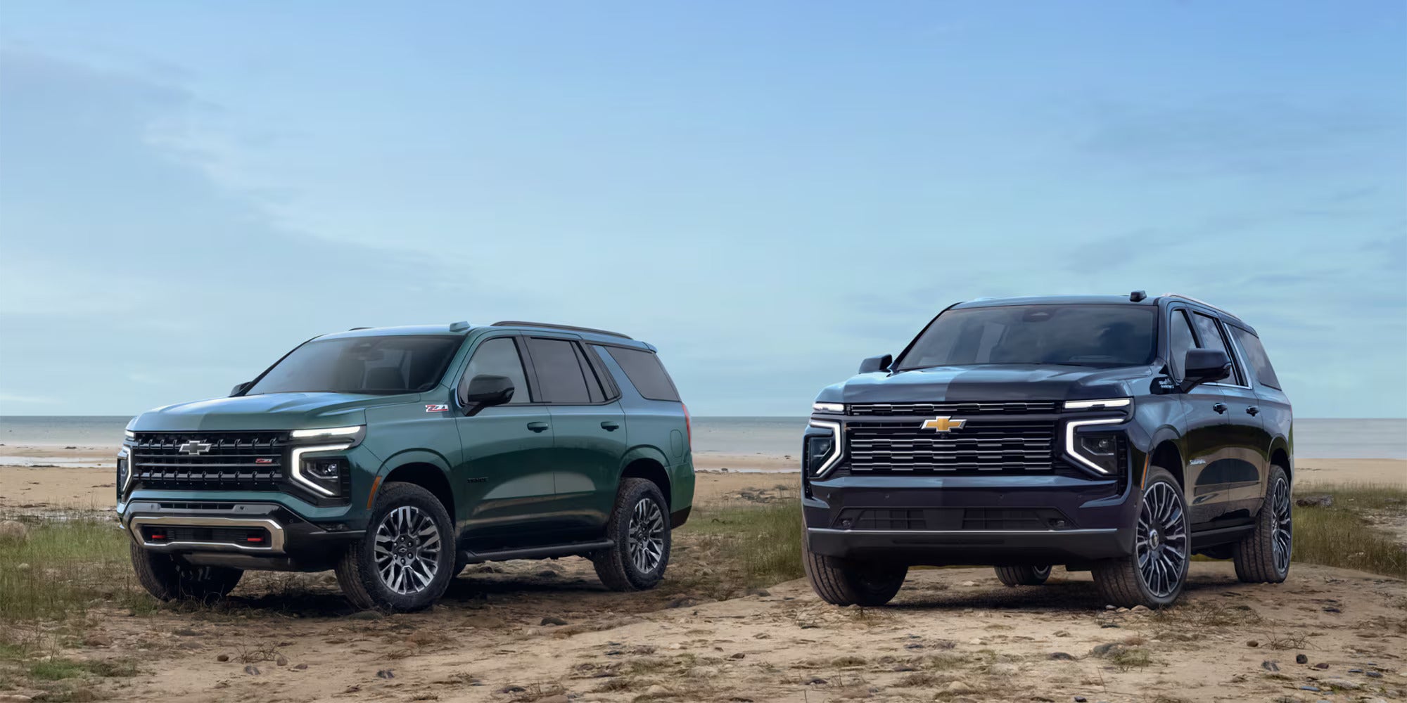 Two suburbans sitting parked.