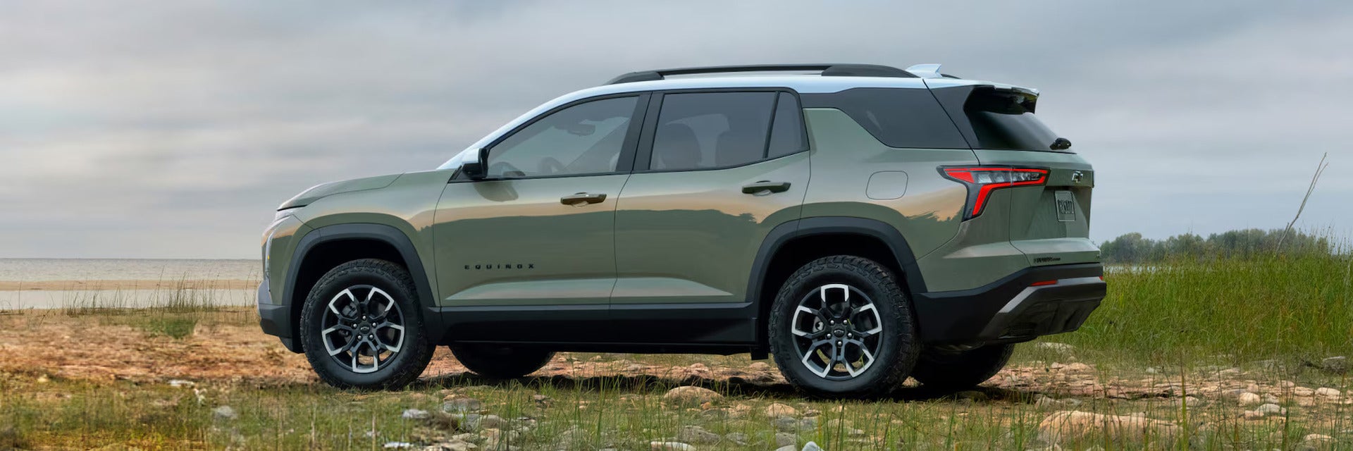 A green suv sitting parked in the grass.